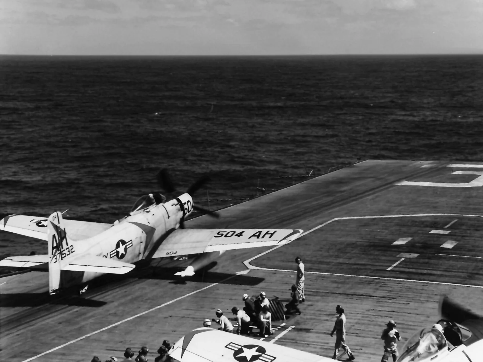 An A-1H Skyraider and sailors on the Oriskany flight deck around 1963
